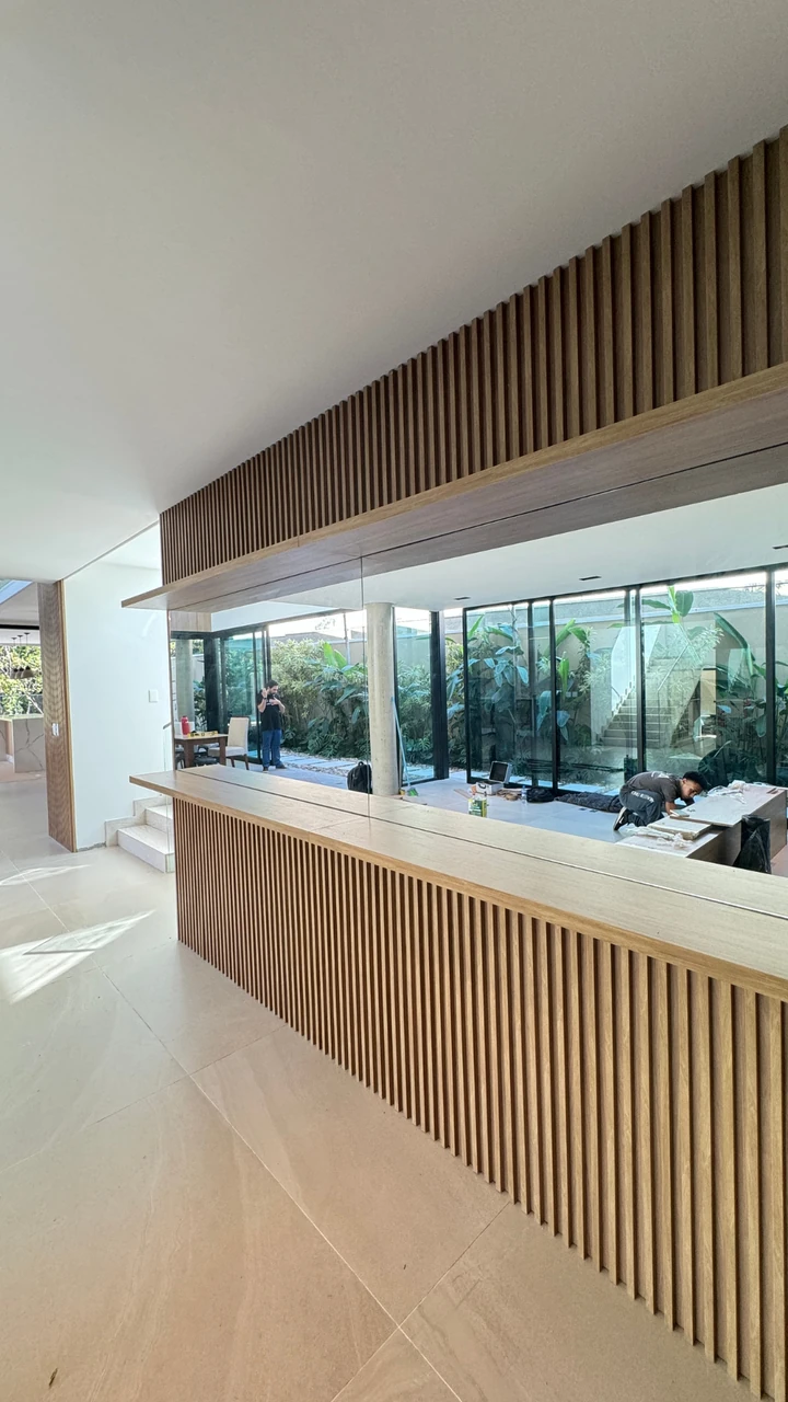 Sala integrada com painel ripado em madeira